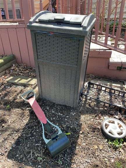 Backyard. Suncast outdoor plastic trashcan, approximately 36 inches tall and natures miracle pooper scooper.