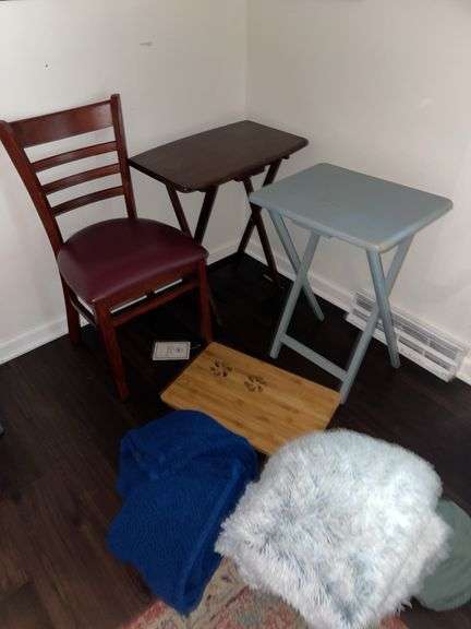 Den. Corner lot featuring wooden chair with cushion. Fold outside tables. And blankets.
