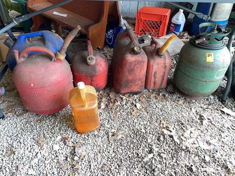 Pole barn. Lot of gas cans, and metal canister.