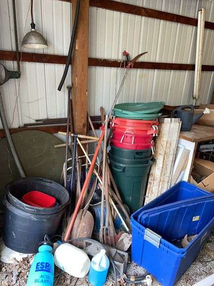Barn. Left wall of barn includes large amount of garden tools, tubs, live trap, sprayer, plastic trash cans.