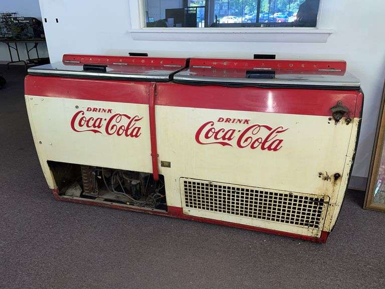 Vintage double well, Coca-Cola cooler. With four doors and what appears to be a lot of the original components. Approximately 69 inches wide 27 inches deep and 36 inches tall.