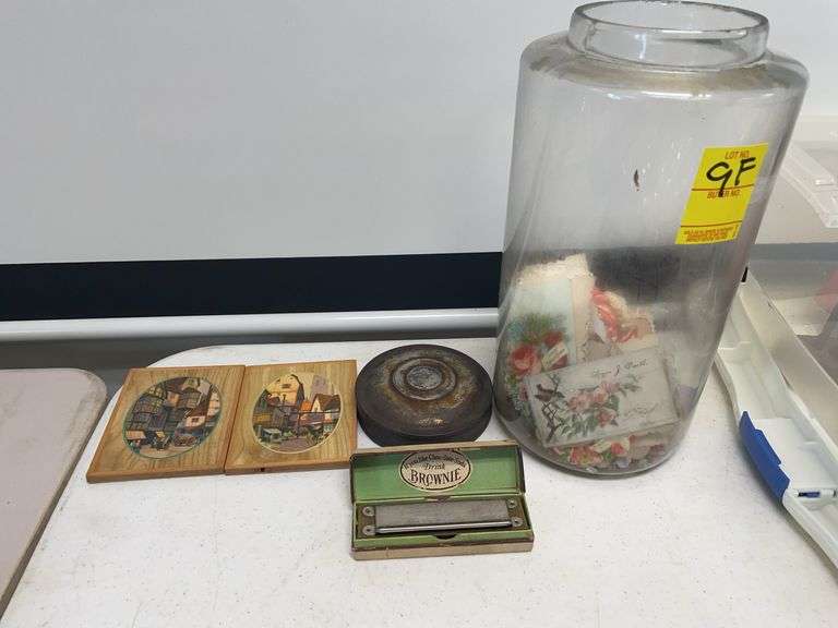 Vintage jar filled with vintage greeting cards with brownie chocolate soda, harmonica advertisement, and two many European scenes