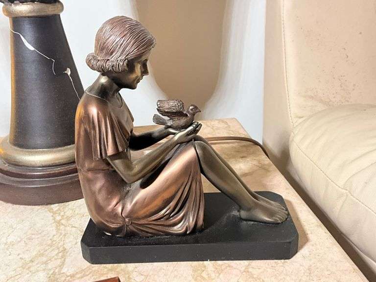 Bronze-Colored Figurine of Seated Woman Holding a Bird on Black Base