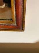Ornate Mirror With Red and Gold Trim Featuring Scrolled Details