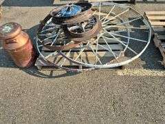 6 Old Spoked Wheels of Various Sizes and 1 Old Style Metal Milk Container