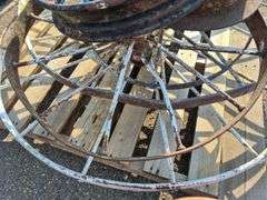6 Old Spoked Wheels of Various Sizes and 1 Old Style Metal Milk Container