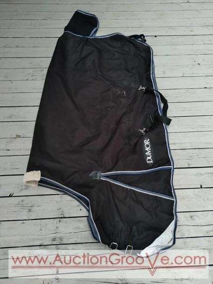 DuMor horse blanket in clean like new condition. Black blanket with blue/white trim is size 75".