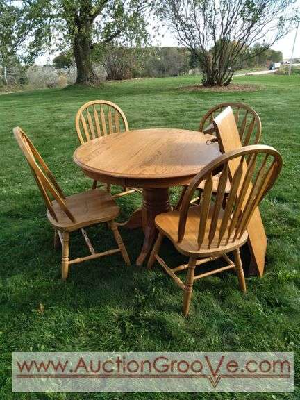 Round Oak Wood Table with one leaf and four chairs. Two chair have water damage on seat, but all in good sturdy condition. Table will be unassembled at pickup, bring strong arms to load. Chairs measu