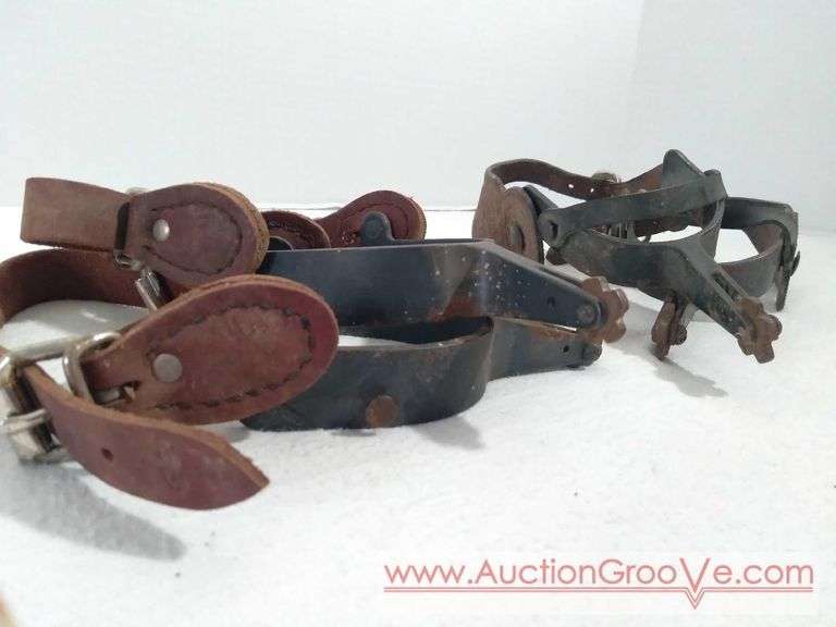 Two sets of vintage cast iron spurs with leather straps. Both sets have 3in heel.