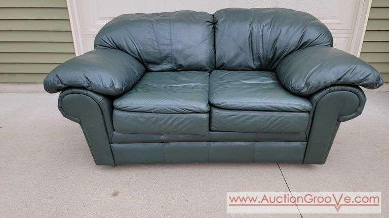 Green Leather Love Seat. Approximately 69 wide x 42 deep and 33 high. Matches couch in previous lot. Spots can use some cleaning. See last few photos where I wiped off an area with a damp rag for abou