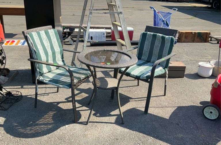 3pc patio set, pair of all weather wicker patio arm chairs, with cushions(stained), glass top table 25”dia, the cushion tie downs are ripped and some rust on chairs