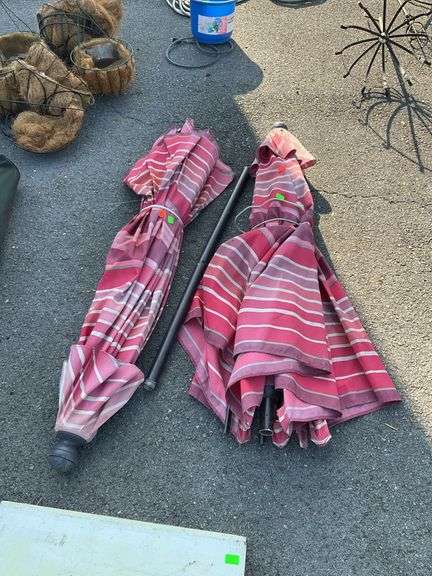 Two outdoor table umbrellas only one with the lower pole, both weathered and used and will sell as is,