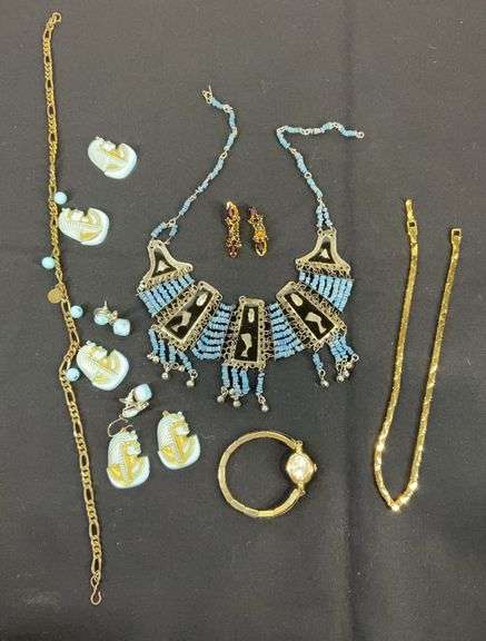Egyptian style jewelry with bib necklace, necklace with matching earrings, goldtone necklace, clip on earrings, and a Wittnauer wrist watch not running