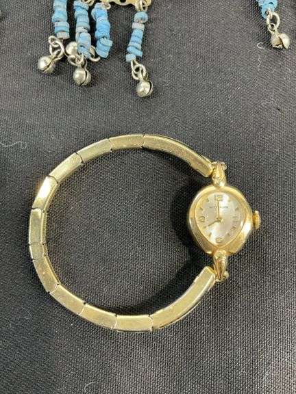 Egyptian style jewelry with bib necklace, necklace with matching earrings, goldtone necklace, clip on earrings, and a Wittnauer wrist watch not running