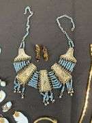 Egyptian style jewelry with bib necklace, necklace with matching earrings, goldtone necklace, clip on earrings, and a Wittnauer wrist watch not running