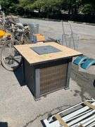 Propane Firepit with Lava Rocks and Woven Cabinet Design