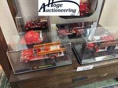 Bottom Shelf - model fire trucks in display boxes, Texaco fire helmet. (trucks include Ford, Packard