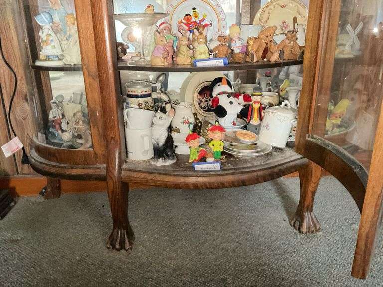 Contents of shelf: elves and other figurines, condensed milk jar, china, misc