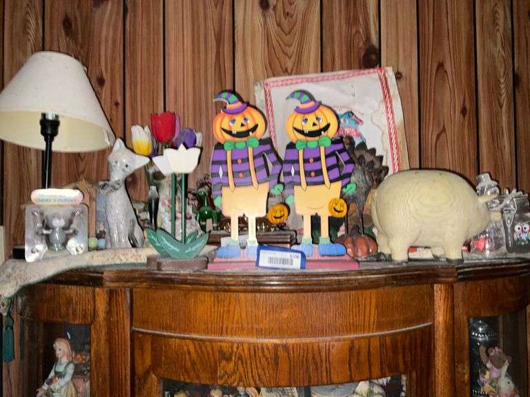 Contents on top of china closet: pumpkin man cutouts, cat figurine, lamp, misc decor items