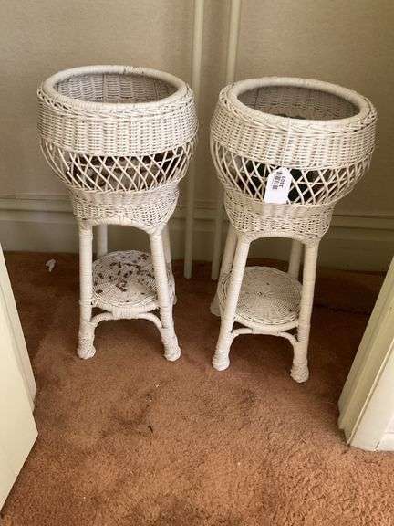 Two white wicker planter stands