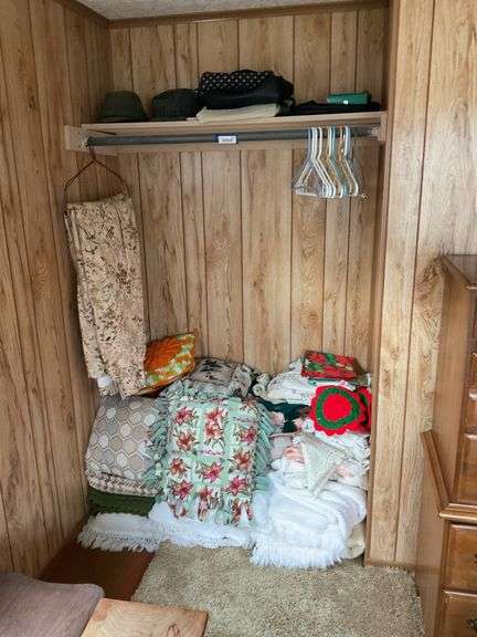 Contents of closet: men's hats, purses, bedspreads, afghans, throw pillows, linens