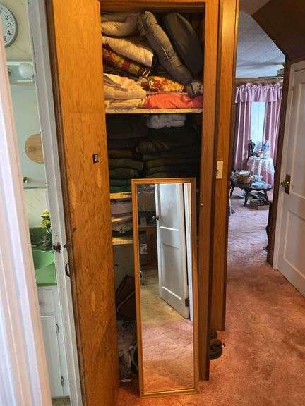 Contents of linen closet including dressing mirror