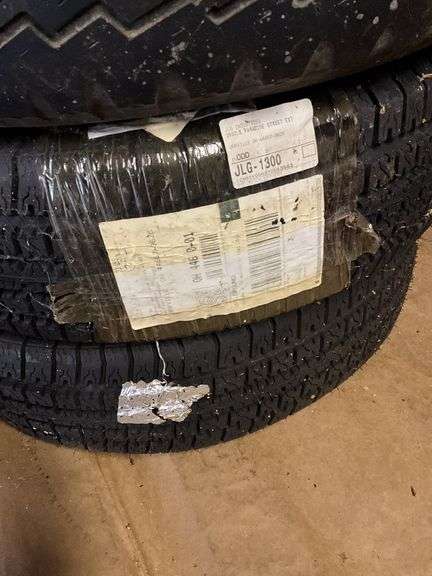 Four tires, one on top is size P225/75R15 - Hurley Real Estate & Auctions