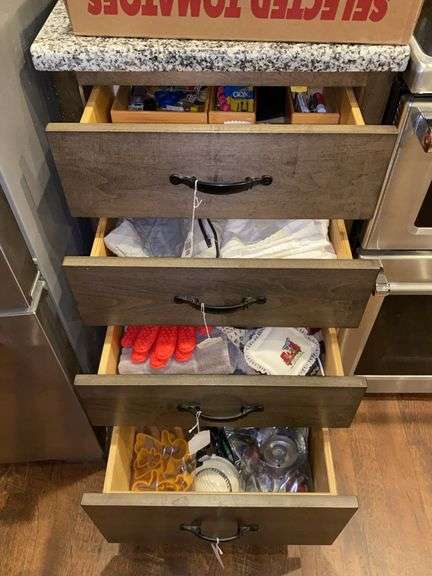 Contents of four drawers: kitchen linens, cookie cutters, gadgets