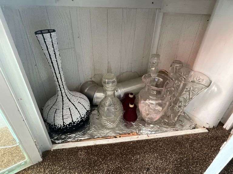 Contents of shelf: beaded vase, glass decanters, vases, ruby votive glasses