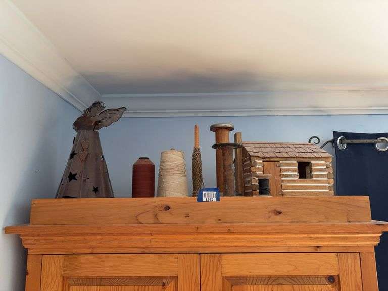 Model log cabin, metal angel figure, yarn spindle and spools