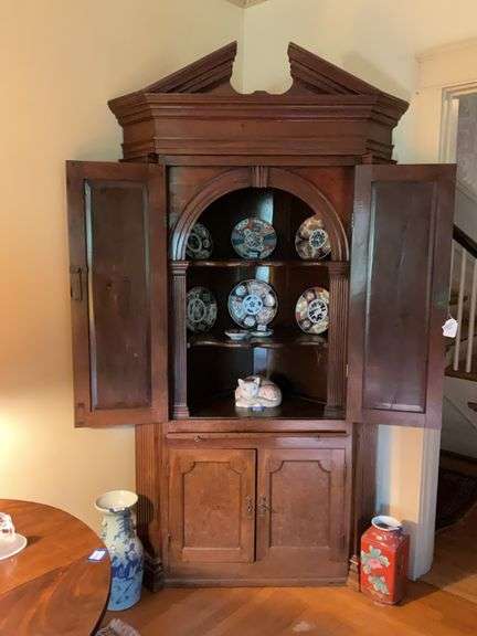 Architectural style corner cupboard w/ open triangular pediment, molded cornice, canted sides w/ fluted pilasters, two paneled doors opening to an arch supported by fluted pilasters, butterfly shelves, paneled doors to cupboard base - no contents 51x20x86