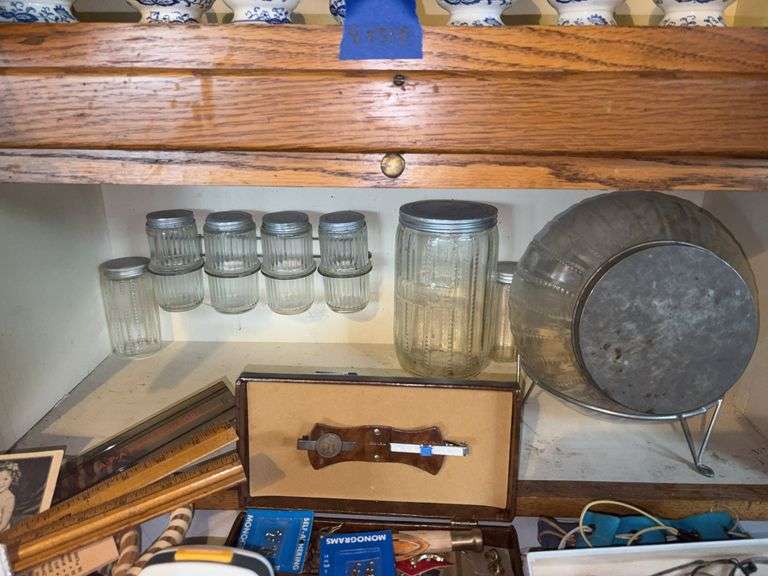 Contents of shelf: glass kitchen cabinet ball storage jar, canisters, and shakers