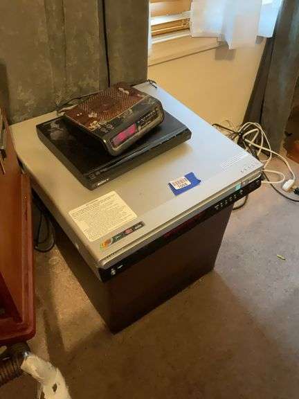 Samsung DVD changer, Sony DVD player, digital clock/radio, and hassock