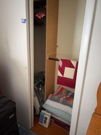 Contents of closet: patchwork quilt, camp blanket, blankets, comforters, linens, dress bag