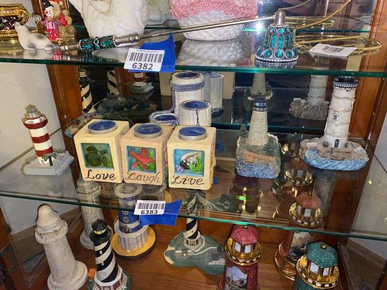 Contents of shelf: lighthouse models, beach theme votive holders