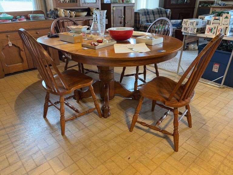 Round oak pedestal extension table w/ lion's paw feet, two leaves, and set of four Windsor chairs - no contents 48x68x30 - MUST COME DURING LAST 2 HOURS OF PICKUP FOR THIS ITEM