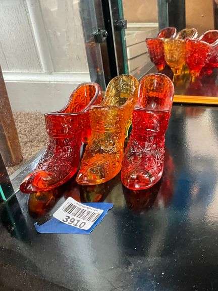 Three Fenton glass Daisy & Button shoes: ruby, amber, amberina