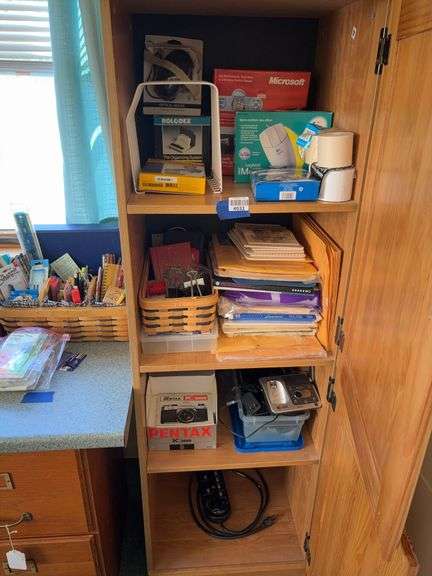 Contents of cupboard: computer mice, envelopes, Pentax K100 camera, power strip, misc