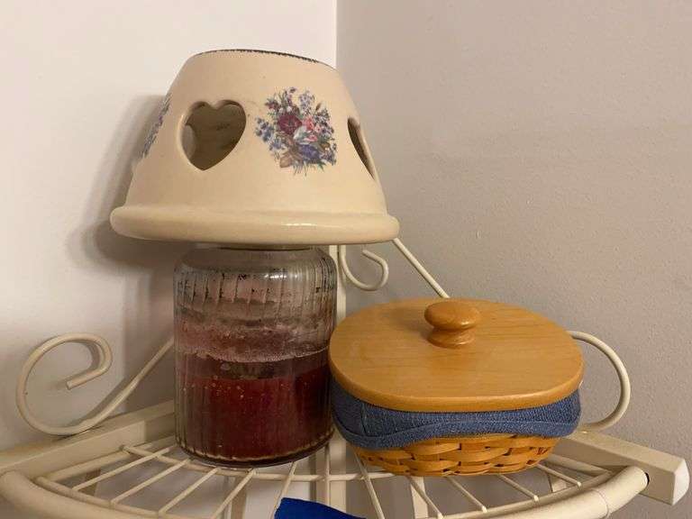 Contents of shelf: jar candle and Longaberger basket