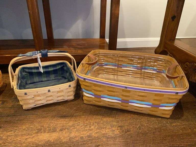 Two Longaberger baskets, one has fabric liner, other has leather handles and plastic liner