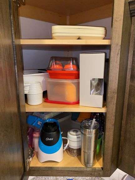 Contents of cupboard: Oster personal blender, plasticware, kitchenware