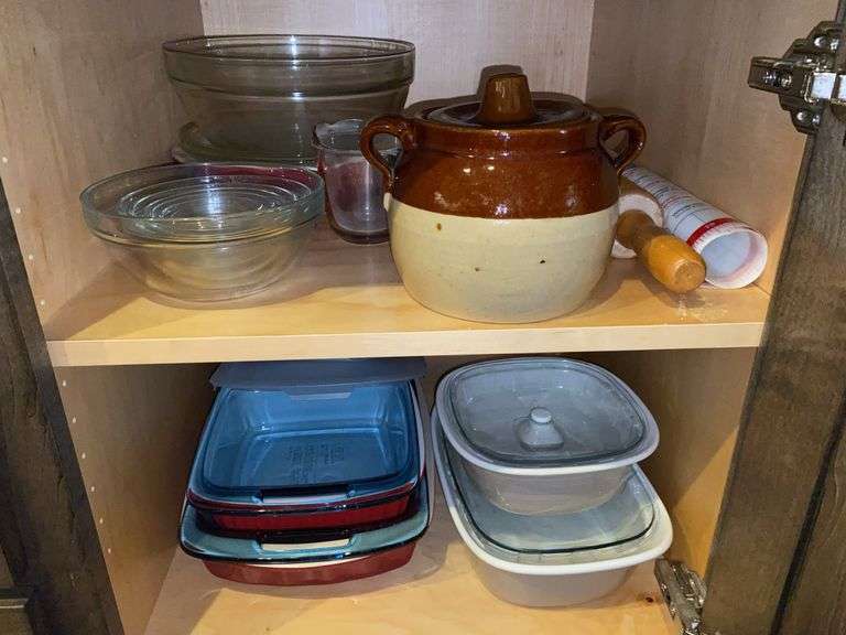 Contents of cupboard: stoneware beanpot, glass mixing bowls, Pyrex meauring cup, rolling pin, baking dishes