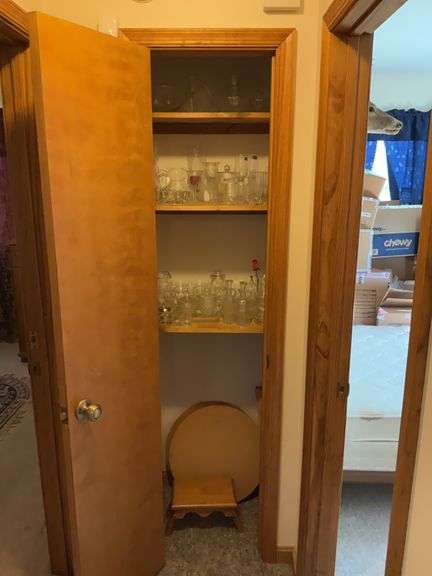 Contents of closet: various glassware including Wexford, glass teapot, wooden stool, round stands