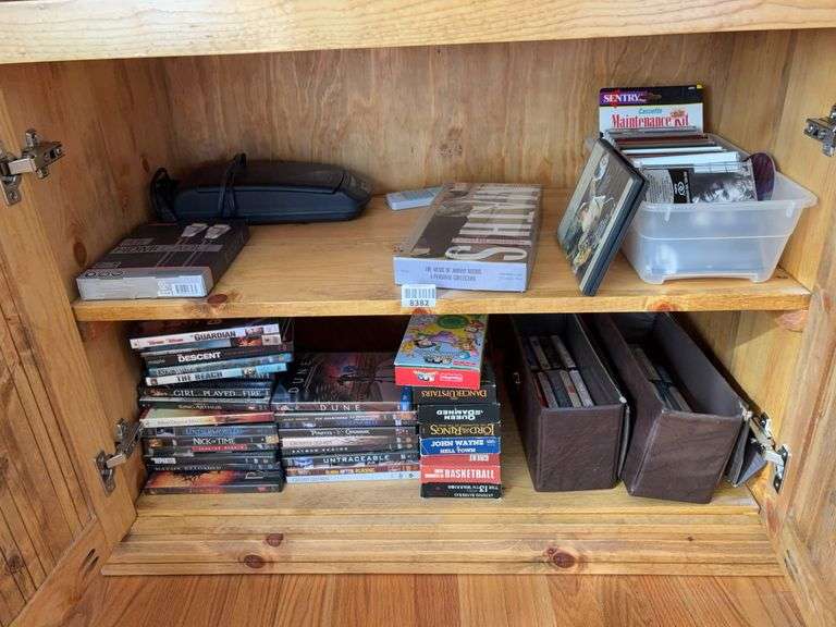 Contents of two shelves: DVDs, CDs, cassette tapes, VHS tapes, tape rewinder