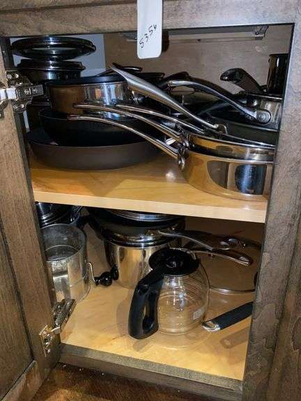 Contents of cupboard: cookware, sifter, glass coffeepot