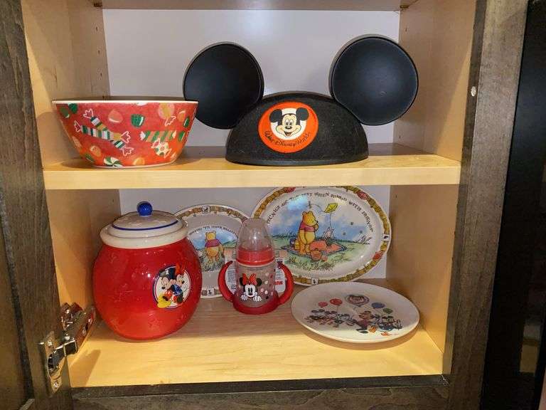 Contents of two shelves: Mickey Mouse ears and covered jar, Minnie Mouse sippy cup. Winnie the Pooh plates, candy bowl
