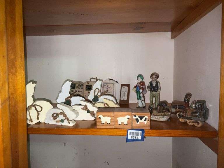 Contents of shelf: figurines, rabbit cutouts, pottery plaques, wooden blocks