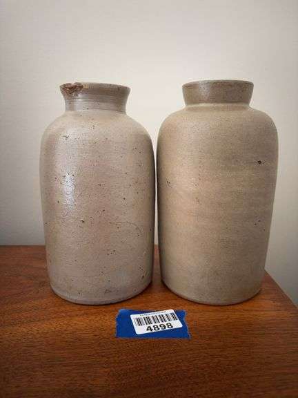 Two stoneware canning jars - note chip on lip of one