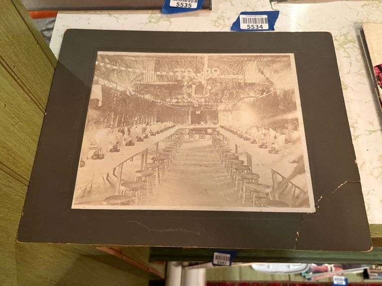 Early B&W photo of a banquet hall w/ tables & stools