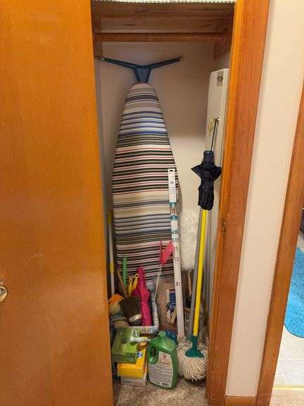 Contents of hall closet: ironing board, cleaning supplies, flashlight, furniture sliders, misc